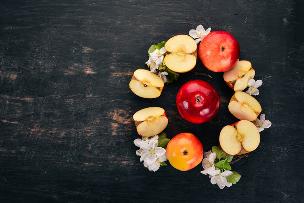 Fresh red apples with inflorescences and leaves. On a wooden background. Top view. Copy space. - Фото, зображення
