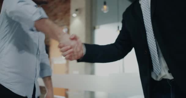 Kaksi toimistotyöntekijää pitää toisiaan kädestä. 4 k.
 - Materiaali, video