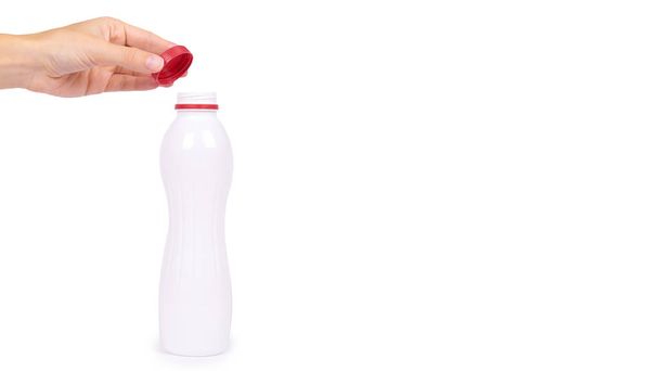 bottle of yoghurt with a red cap in hand isolated on white background, healthy lifestyle, plastic container for milk. copy space, template - Fotoğraf, Görsel