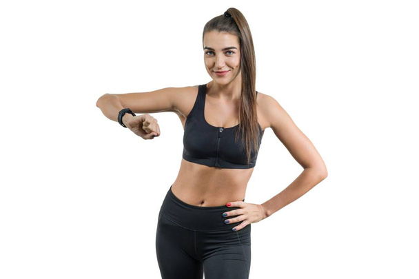 Portrait of smiling young female looking at wrist watch, fitness woman in sportswear, isolated - Foto, Imagem