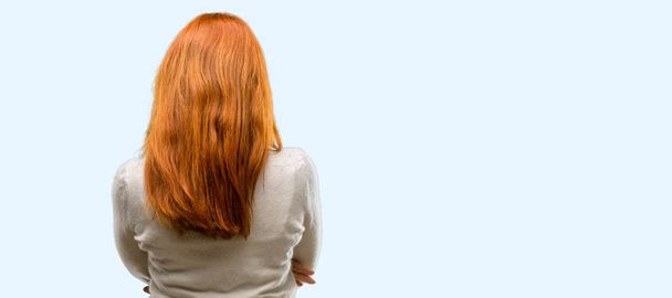 Beautiful young redhead woman backside, rear view isolated over blue background - Fotografie, Obrázek