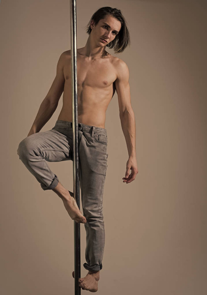 Athlete, sportsman performing pole dancing moves, work out, show trick. - Фото, зображення