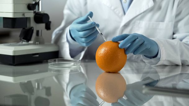 Scientist preparing anti-cellulite extract from orange peel, cosmetic laboratory - 写真・画像