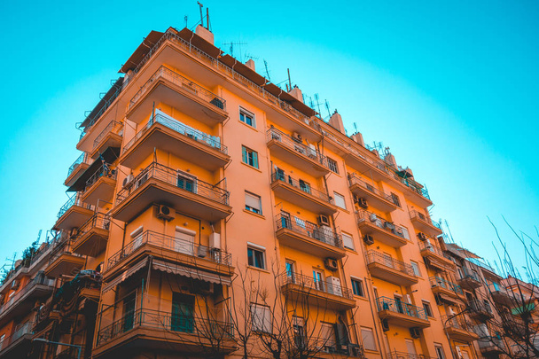 テッサロニキの中心部にあるオレンジ色の建物の低い角度の眺め - 写真・画像