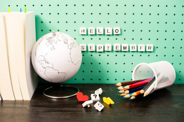 Back to school supplies pastel workspace with trendy items, globe and wooden letters on a board - Photo, Image