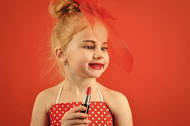 Makeup retro look and hairdresser. Child girl in stylish dress, makeup. Little girl hold lipstick and mirror. Retro girl fashion with cosmetics, beauty. Fashion and beauty, pinup style, childhood - Foto, immagini