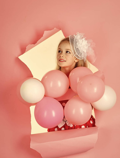 Little girl with balloons on a pink background. - Foto, afbeelding