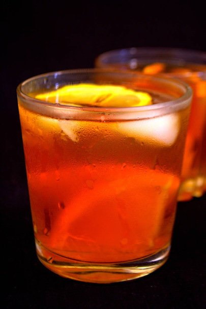 Iced tea with lemon and orange. Refreshing drinks. Black background - Photo, Image