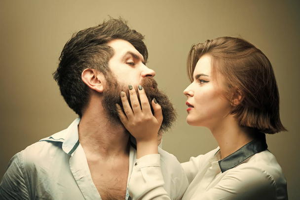 Woman hairdresser making shape of beard, touches. Man with long beard, mustache and stylish hair, light background. Guy with modern hairstyle visited hairdresser. Barbershop or hairdresser concept - Fotoğraf, Görsel