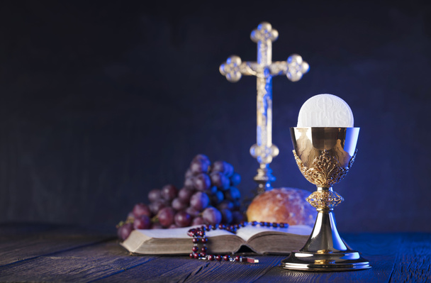 Primeiro tema da santa comunhão. A Cruz, a Bíblia Sagrada, o rosário e o cálice de ouro. Pão e uvas símbolos do cristianismo
. - Foto, Imagem