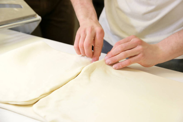 Making dough by male hands at bakery closeup - Foto, Imagem