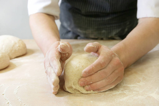 Making dough by male hands at bakery closeup - Fotoğraf, Görsel