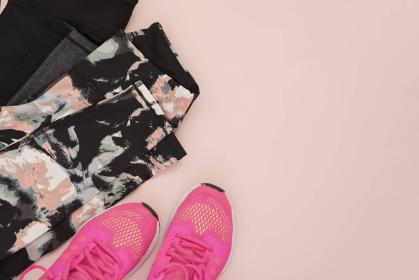 Female pink sneakers, sport shoes, leggings in flat lay style, top view. Fitness concept, active lifestyle, body care concept. Copy space - 写真・画像