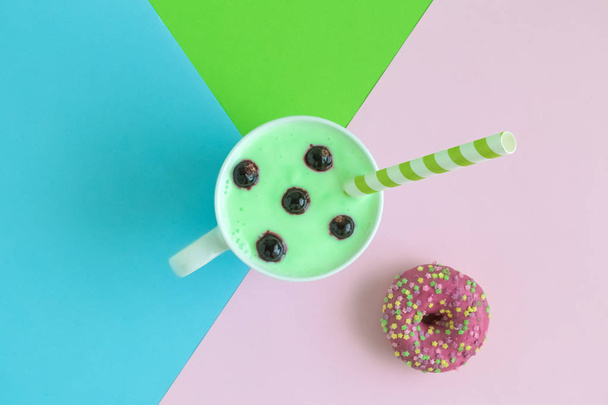 Cup of blueberries smoothie and donut on colorful background. - Foto, Imagem