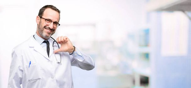 Médecin sénior, professionnel de la santé fier, excité et arrogant, pointant avec victoire visage à l'hôpital
 - Photo, image
