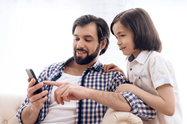 Happy father and son use smartphone at domestic. - Valokuva, kuva