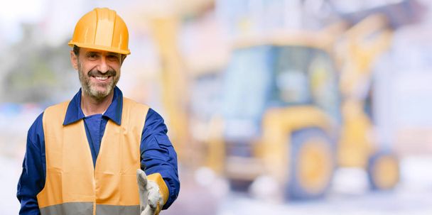 シニア エンジニア男、建設労働者を保持する手握手ポーズを歓迎する、信頼と成功のコンセプトを表現する、職場での挨拶 - 写真・画像