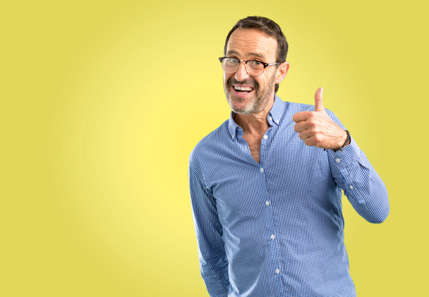 Handsome middle age man smiling broadly showing thumbs up gesture to camera, expression of like and approval - Photo, Image