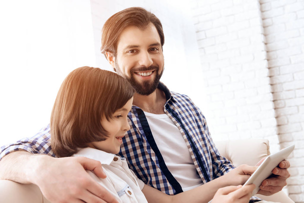 Pai feliz e filho jovem estão olhando para tablet computador
. - Foto, Imagem