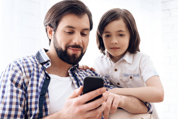 Happy father and son use smartphone at domestic. - Valokuva, kuva