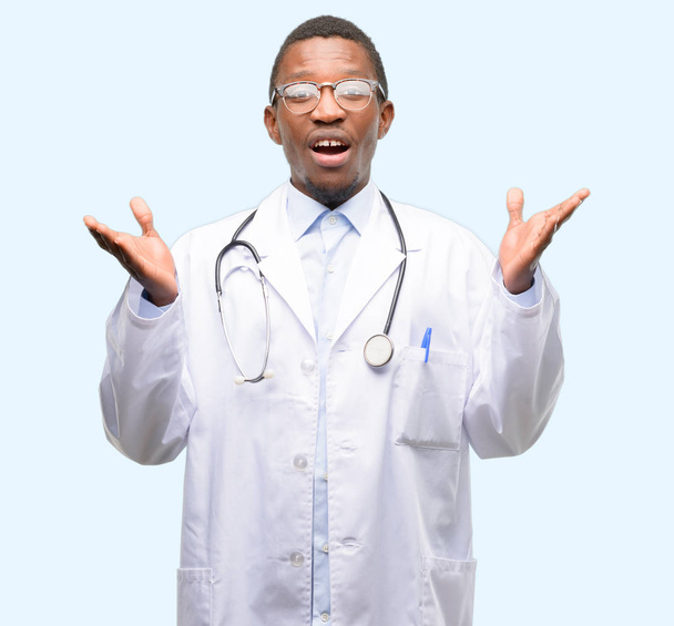 Young black doctor, medical professional happy and surprised cheering expressing wow gesture - 写真・画像
