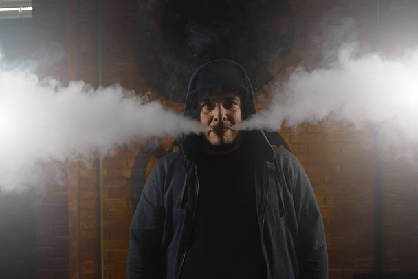 Hombre en una nube de humo de vapor blanco
 - Foto, Imagen