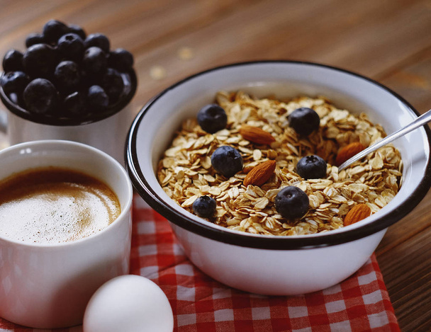 Un petit déjeuner sain - porridge aux flocons d'avoine, oeuf cuit, lait, baies fraîches et café. Un bon début pour un nouveau jour
. - Photo, image