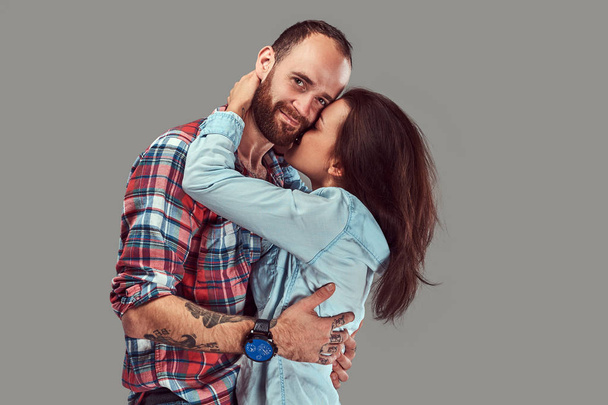 Atrakcyjna para, brodaty mężczyzna i brunetka dziewczyna przytulanie w studio. - Zdjęcie, obraz