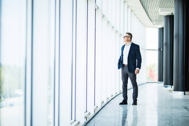 Empresário maduro sênior caminhando no prédio de escritórios moderno. Homem de negócios bem sucedido vestindo terno e gravata
. - Foto, Imagem