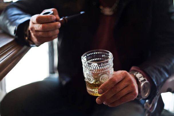oříznutý pohled člověka sedí se sklem alkoholických nápojů a kouření tube - Fotografie, Obrázek