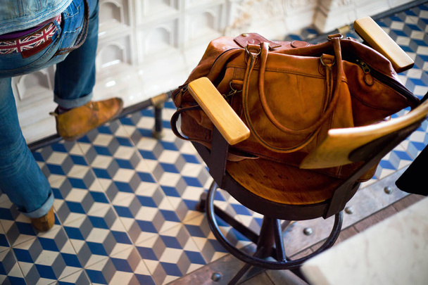 vista elevata della borsa in pelle sulla sedia da bar in legno
  - Foto, immagini