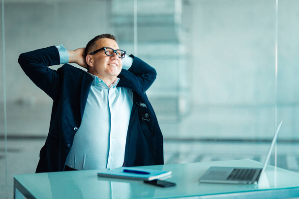 Успешный старший бизнесмен, сидящий, размышляя над проблемой или новой идеей, расслабляется в своем кресле в офисе с руками за головой
 - Фото, изображение