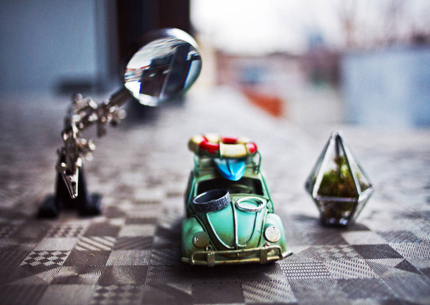 closeup view of toy car with rings and magnifier on patterned surface  - Photo, Image
