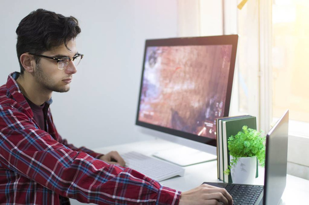 jeune homme avec ordinateur travaillant ou étudiant au bureau
 - Photo, image