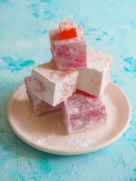Eastern sweets. Turkish delight in a dish on a blue background. - Photo, Image