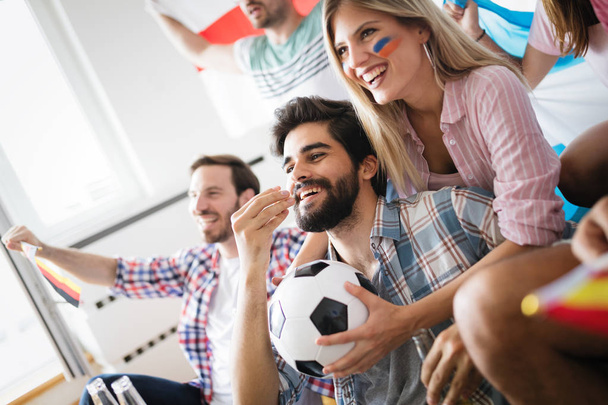 Vrolijk en gelukkig groep vrienden kijken naar voetbalwedstrijd op tv. - Foto, afbeelding