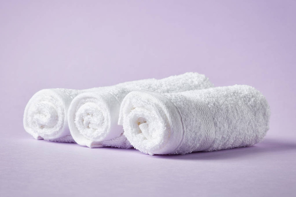Ręczniki białe spa na fioletowym tle - Zdjęcie, obraz