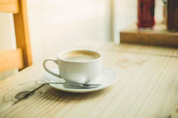 A cup of coffee on a table by the window in a cafe - 写真・画像