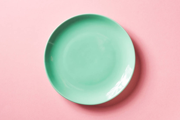 Green plate on pink background, from above - Fotografie, Obrázek