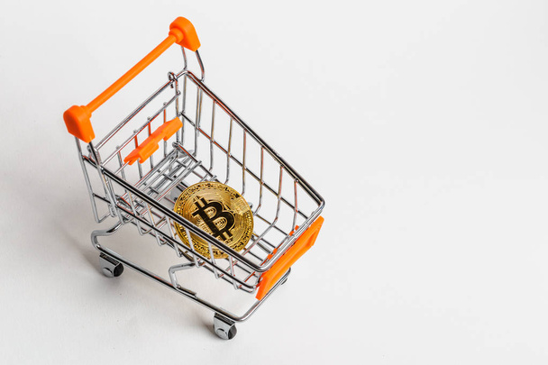 Criptomoeda moeda de ouro bitcoin no carrinho de compras - símbolo do comércio eletrônico, compras on-line - dinheiro virtual no fundo branco
 - Foto, Imagem