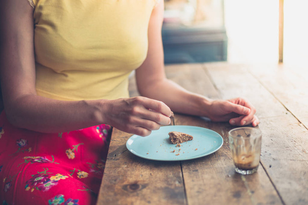 Young woman eating cookie in cafe - Foto, Bild