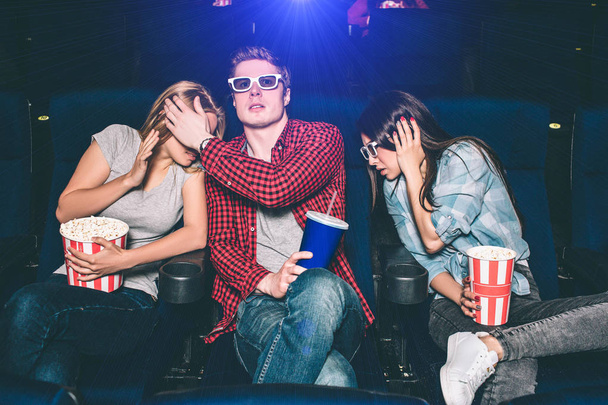 怖いとおびえる人々 を映画館で映画を見ています。彼らは座って、まっすぐ進みます。誰もがポップコーンやコーラとカップのバスケットです。彼らはホールだけではないです。. - 写真・画像
