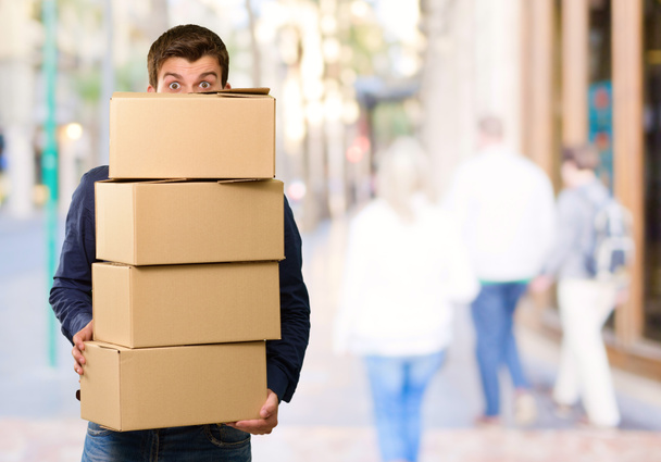 Hombre sosteniendo cajas de cartón
 - Foto, Imagen