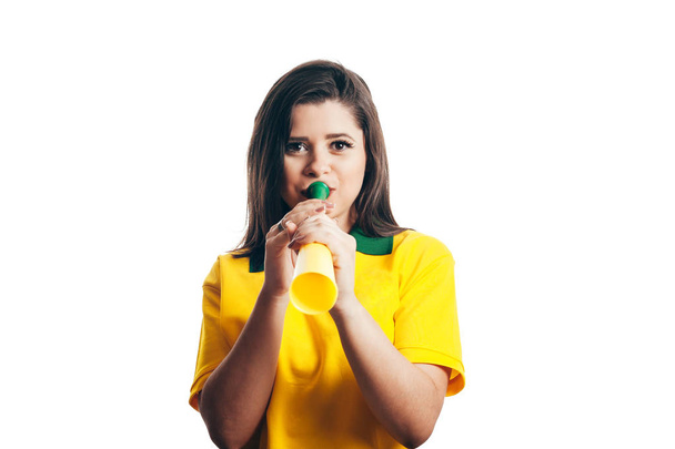 Abanico brasileño animando con un cuerno de plástico aislado sobre fondo blanco
 - Foto, imagen