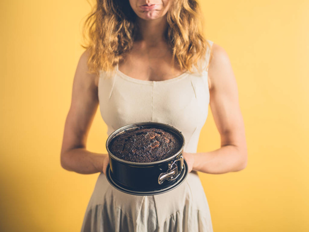 Sad woman with burnt cake - Фото, зображення