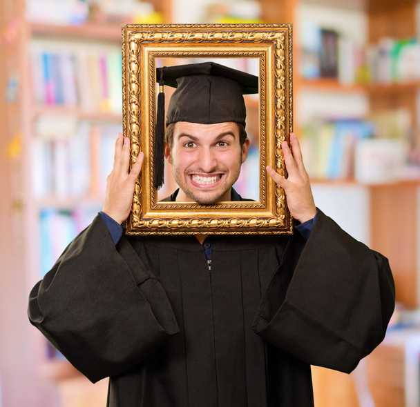 Homme diplômé regardant à travers un cadre
 - Photo, image