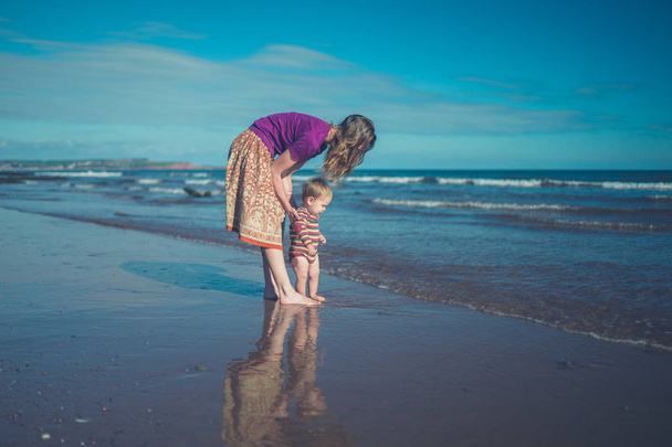 Madre y bebé en la playa
 - Foto, imagen