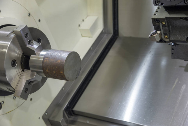 La máquina de torno CNC que arroja la materia prima
  - Foto, imagen