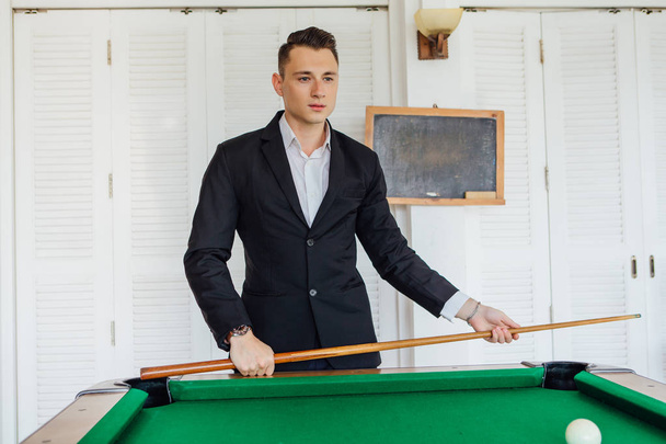 Young handsome man playing billiard game alone - Foto, afbeelding