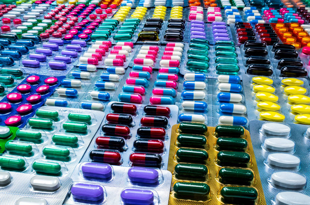 Värikäs tabletteja ja kapseleita pilleri läpipainopakkauksessa järjestetty kaunis kuvio. Lääketeollisuuden konsepti. Apteekkiapteekki. Virheellinen ja virheellinen lääketehtaan käsite
. - Valokuva, kuva